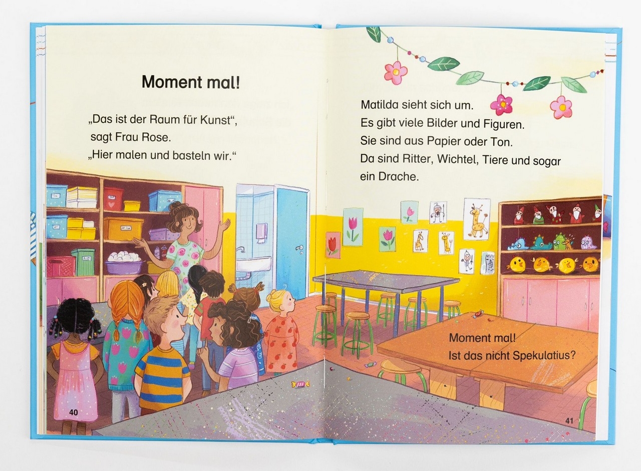Spekulatius geht in die Schule - Matilda findet Spekulatius im Kunstraum: Zu sehen sind Kinder mit ihrer Lehrerin in einem Atelier mit Mal- und Bastelmaterial.